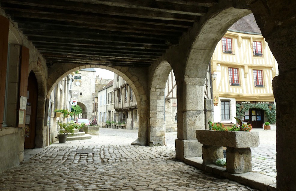 Sous les arcades de la grande place de Noyers-sur-Serein.